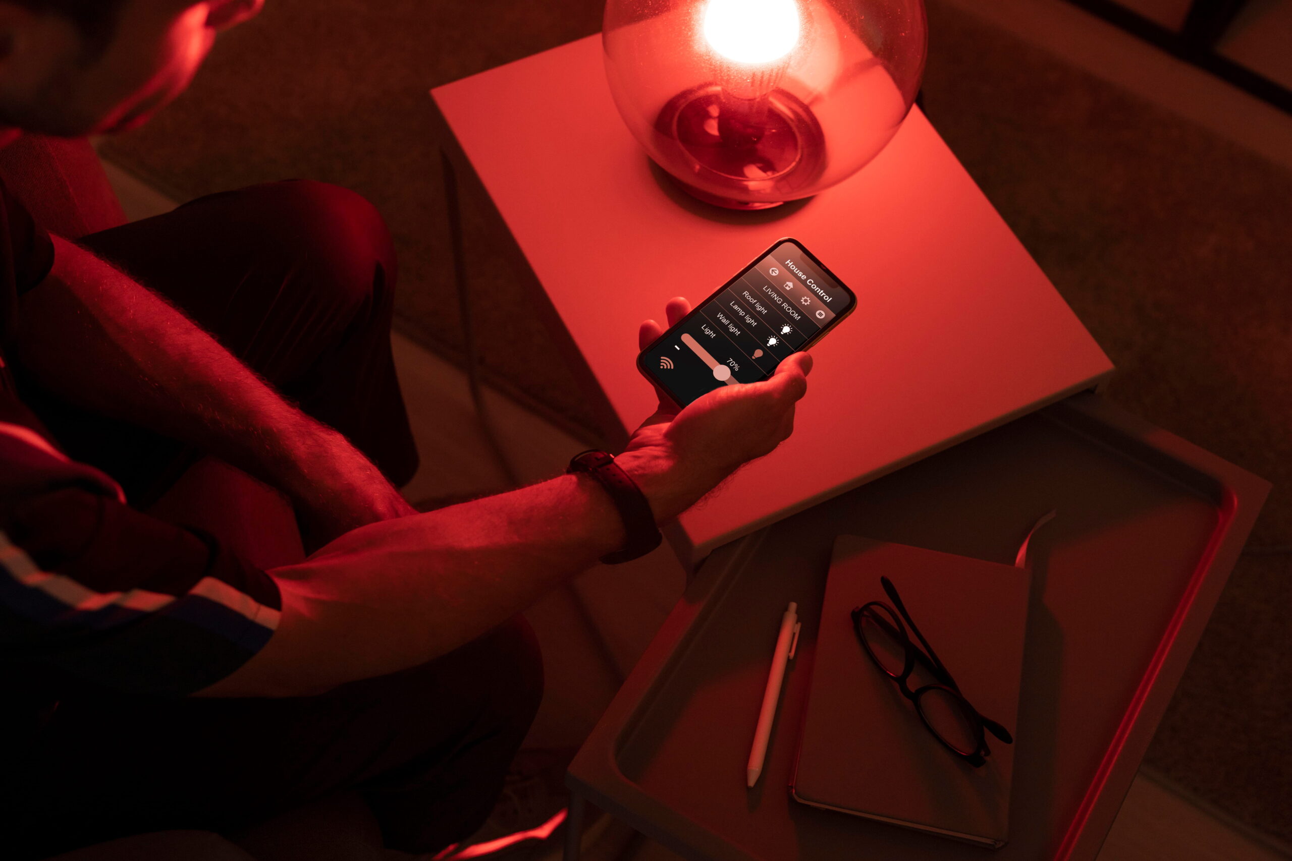 man-controlling-smart-lamp-with-his-phone